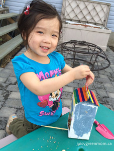 girl with DIY recycled bird feeder